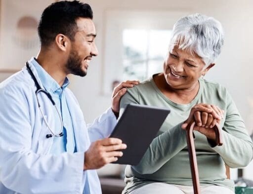 A young doctor sharing information about symptoms of Depression in older adults from his digital tablet with an older patient