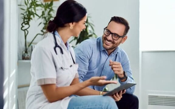 A doctor and patient engage in a friendly conversation about esketamine as a glutamate depression treatment